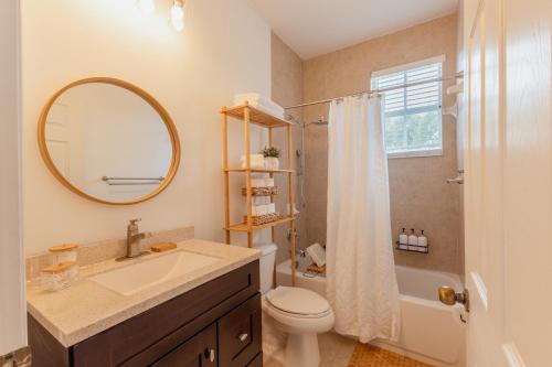 ein Badezimmer mit einem Waschbecken, einem WC und einem Spiegel in der Unterkunft Miami Luxury Villa Heated Pool & Pool Table 5BD 4BR in Miami