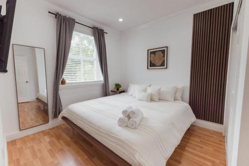 a bedroom with a large white bed with towels on it at Miami Getaway Heated Pool Villa with Mini Golf & BBQ in Miami