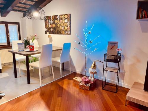 un comedor con una mesa y un árbol pintado en la pared en StaraGo Apartment, en Gorizia