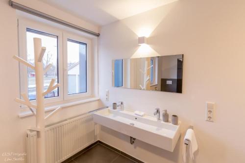 a bathroom with a sink and a mirror and a window at Ferienhaus Taubenhof in Simprechtshausen