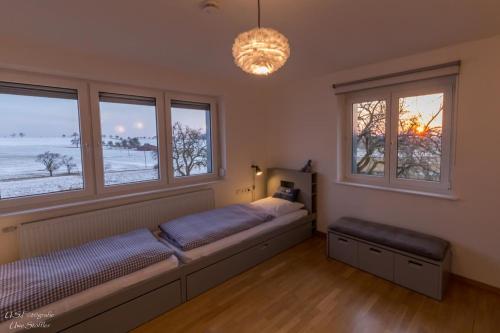 1 dormitorio con 1 cama y 2 ventanas en Ferienhaus Taubenhof, en Simprechtshausen