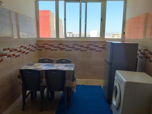 um quarto com uma mesa e cadeiras e um frigorífico em Appartement meublé situé a côté de centre ville em Meknès
