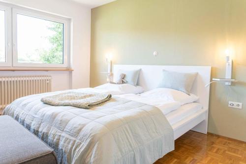 a bedroom with a white bed with two candles on it at Haus Grün in Niederstetten