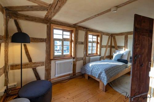 ein Schlafzimmer mit einem Bett und zwei Fenstern in der Unterkunft Ferienwohnung Türmerwohnung in Öhringen
