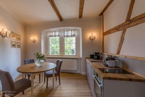 eine Küche und ein Esszimmer mit einem Tisch und einem Fenster in der Unterkunft Apartment Lindenplatz in Langenburg