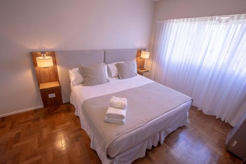 a bedroom with a bed with two towels on it at El Misti Coliving Obelisco in Buenos Aires