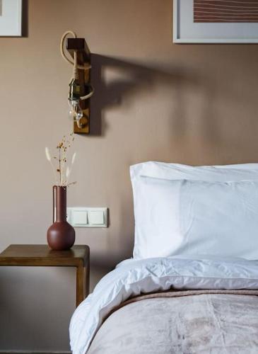 a bedroom with a bed and a vase with flowers on a table at vaya_living in Ktistádes