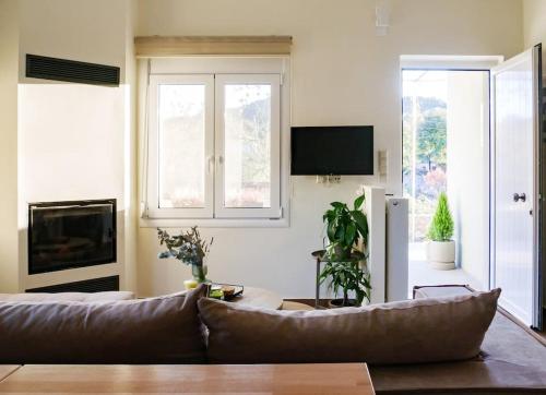 a living room with a couch and a tv at vaya_living in Ktistádes