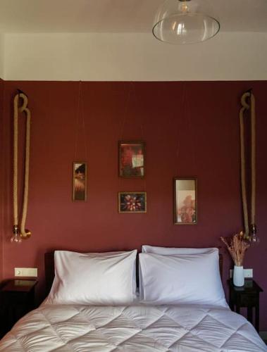 a bed in a bedroom with a red wall at vaya_living in Ktistádes