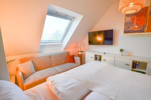sypialnia z łóżkiem, kanapą i oknem w obiekcie Gemütliches Apartment im Zentrum w Augsburgu