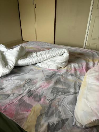 an unmade bed with sheets and pillows on it at Gardenlea in Durban