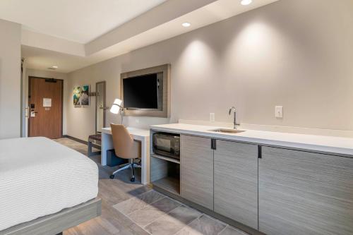 a bedroom with a bed and a sink and a desk at Cambria Hotel Lake Placid - Lakeside Resort in Lake Placid