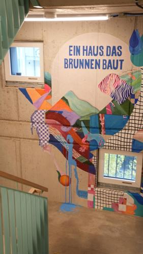 a wall with a painting of colorful kites on it at Villa Viva - ein Haus das Brunnen baut in Hamburg