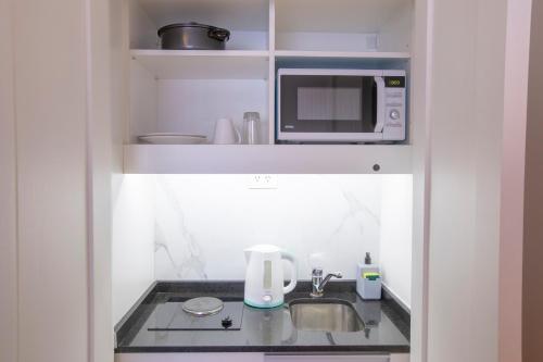 a small kitchen with a sink and a microwave at El Misti Coliving Obelisco in Buenos Aires