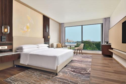 ゴーラクプルにあるCourtyard by Marriott Gorakhpurのベッドルーム(白いベッド1台、大きな窓付)