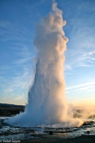 a geyser in the middle of a field at Litli Geysir Hotel in Haukadalur