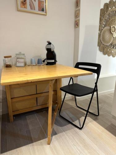 a wooden desk with a black chair next to it at Le Petit Studio in Avignon