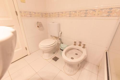 a white bathroom with a toilet and a sink at El Misti Coliving Obelisco in Buenos Aires