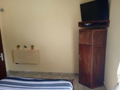 - une chambre avec une télévision sur une commode et un lit dans l'établissement Logement Petit Studio Salazamay Tamatave Madagascar, à Toamasina