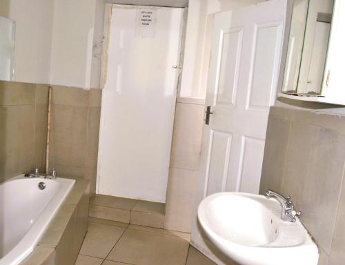 a bathroom with a sink and a tub and a toilet at HOME AWAY FROM HOME in Cape Town