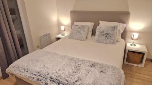 um quarto com uma cama branca e 2 candeeiros em TERRASSES DE MALMEDY Triplex 262 SWEET HOME em Malmedy