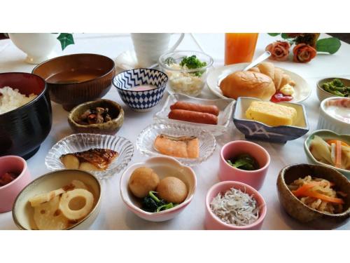 a table topped with bowls of different types of food at Business Green Hotel Hino - Vacation STAY 16322v in Hino