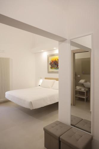 a white bedroom with a bed and a mirror at Ruffini Rooms in Termoli