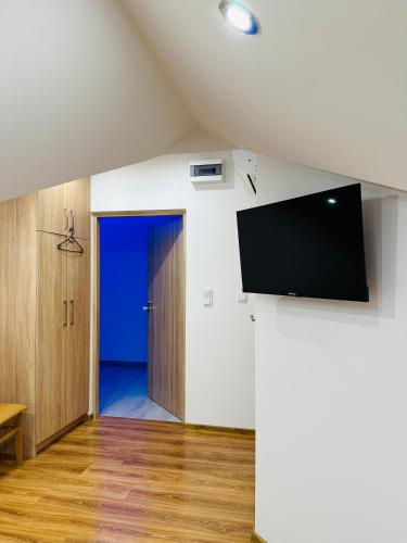 a living room with a flat screen tv on a wall at Pietro Pokoje B&B Czarna in Czarna