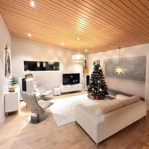 a living room with a christmas tree and a couch at Gorgeous Arctic Lodge in Rovaniemi
