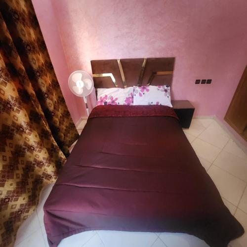 1 dormitorio con 1 cama grande con sábanas moradas en B 12 apartment, en Fez