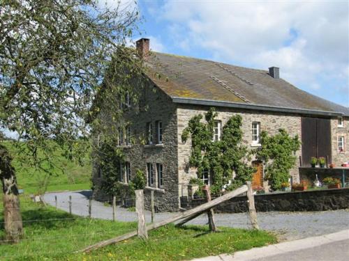 an old stone house with a fence in front of it at A Tchapè Mèlé in Gouvy