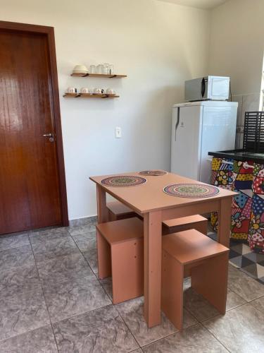 a kitchen with a wooden table and a refrigerator at Apartamento cachoeira in Florianópolis