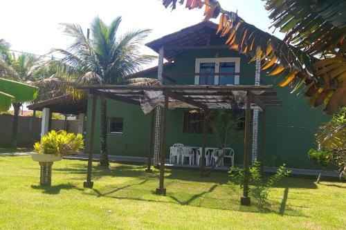 a green house with two chairs in a yard at Casa em Iguape praia da Juréia in Iguape