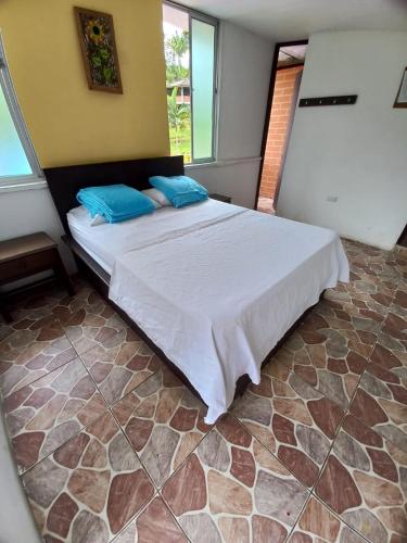 a bedroom with a bed with blue pillows on it at Centro Integral Coodecom in Manizales