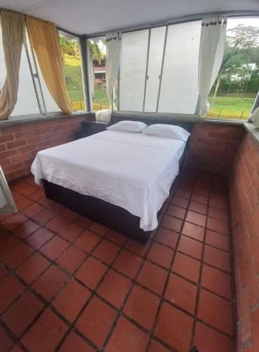 a bedroom with a bed in a room with windows at Centro Integral Coodecom in Manizales