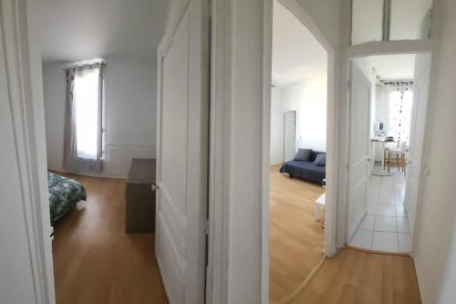 uma sala de estar com um sofá azul e um espelho em Appartement Accueillant em Vitry-sur-Seine