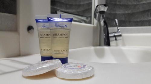 un lavandino in bagno con due spazzolini da denti e una bottiglia di crema solare di اريس الشرق للشقق المخدومة a Gedda
