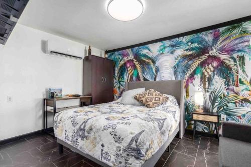 um quarto com uma cama com um mural de palmeiras em Your Tiny Downtown Home with Backyard Unit D em Phoenix