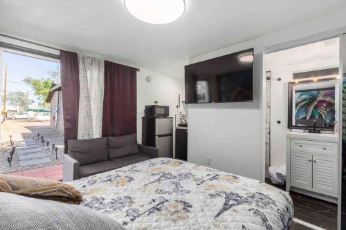 a bedroom with a bed and a flat screen tv at Your Tiny Downtown Home with Backyard Unit D in Phoenix