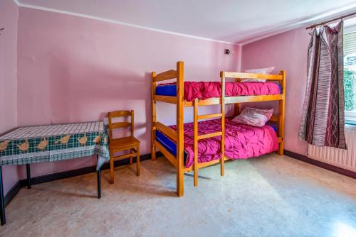 a bedroom with two bunk beds and a chair at Les Bucherons in Awenne