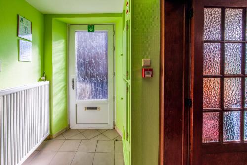 a hallway with a white door and green walls at Les Bucherons in Awenne