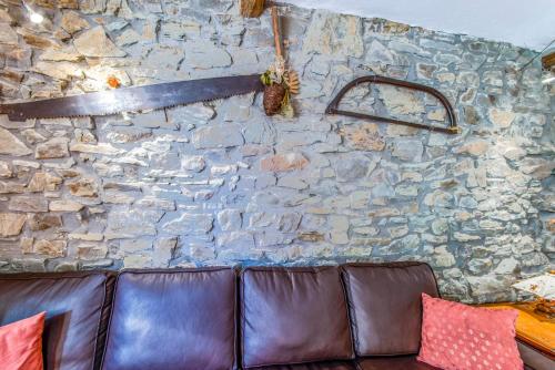 a stone wall with a leather couch against a stone wall at Les Bucherons in Awenne