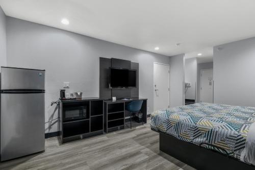 a bedroom with a bed and a flat screen tv at Studio 6 Suites Perris, CA in Perris