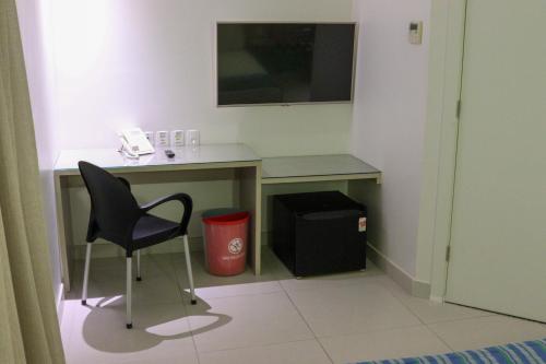 a room with a desk with a chair and a phone at Go Inn Hotel Aracaju in Aracaju