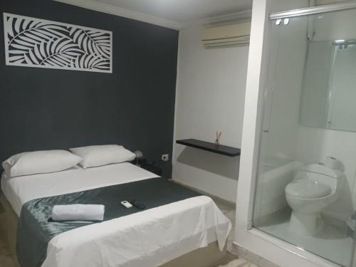 1 dormitorio con 1 cama y baño con aseo en HOTEL CASA LUKE, en Neiva