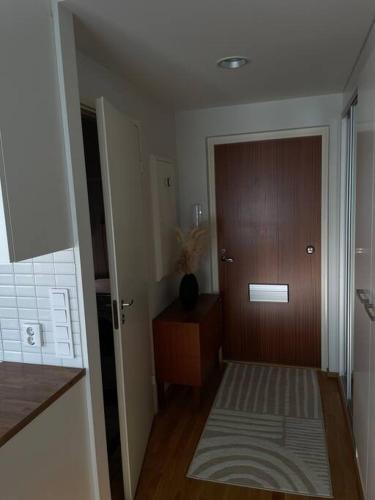 Cette chambre dispose d'un couloir avec une porte en bois. dans l'établissement Cozy Top-Floor Studio in Turku - Near City Center, à Turku