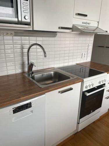 a kitchen with a sink and a stove at Cozy Top-Floor Studio in Turku - Near City Center in Turku