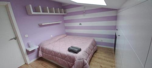 a small bedroom with purple and purple stripes at Espectacular Ático con garaje a 10 minutos de Valladolid in Valladolid