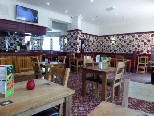 a dining room with wooden tables and chairs at The Cabbage Hall Hotel in Liverpool