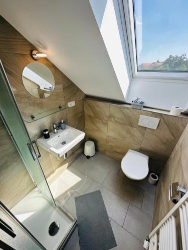 a bathroom with a sink and a toilet and a window at Restaurace - penzion Bavorský dvůr in Sezemice